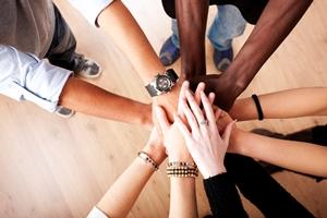 Hands of different people held together in symbol in cooperation